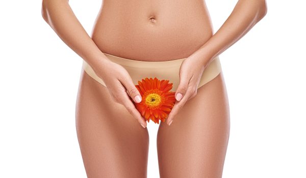 Young woman is showing her beautiful thigh with flower. Attractivel slim lady prefers comfortable underwear